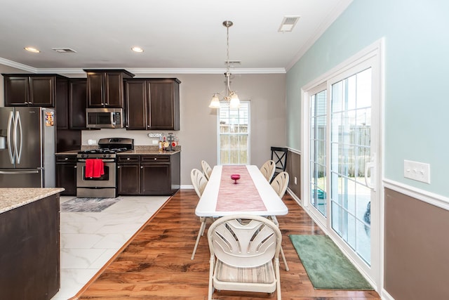 kitchen with visible vents, stainless steel appliances, dark brown cabinetry, and pendant lighting