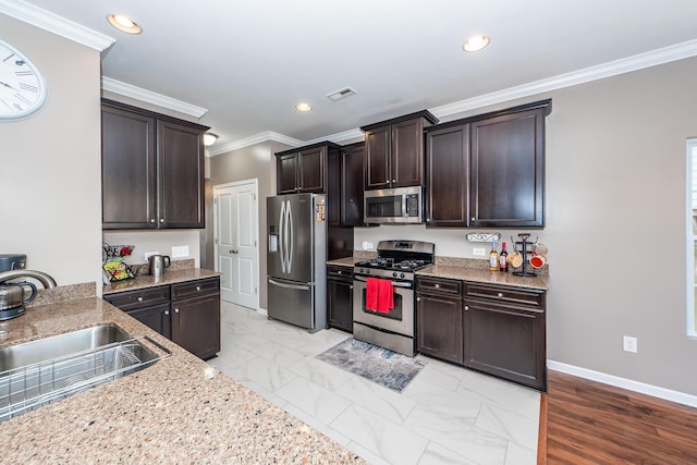 kitchen with a sink, visible vents, stainless steel appliances, and dark brown cabinets