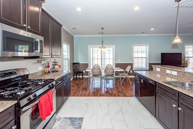 kitchen with dark brown cabinetry, appliances with stainless steel finishes, ornamental molding, light stone countertops, and pendant lighting