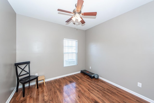 spare room with dark wood finished floors, a ceiling fan, and baseboards