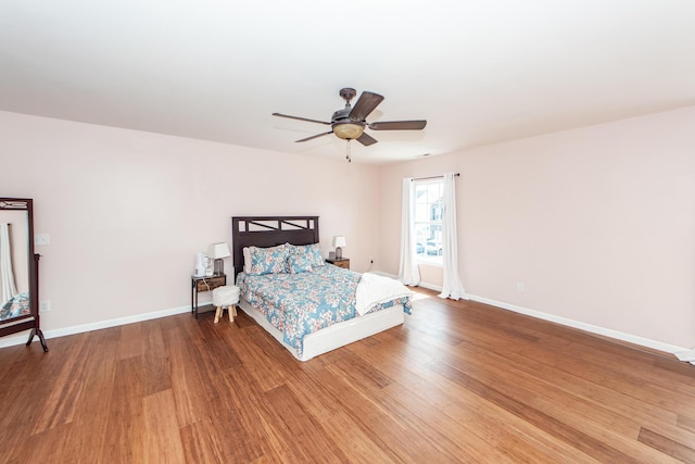 bedroom featuring ceiling fan, wood finished floors, and baseboards