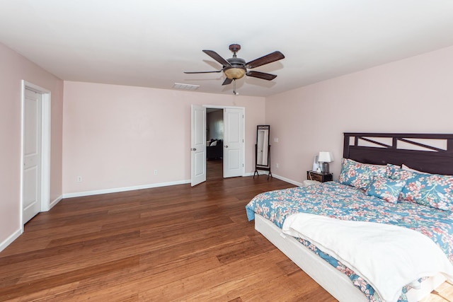 bedroom featuring ceiling fan, wood finished floors, visible vents, and baseboards