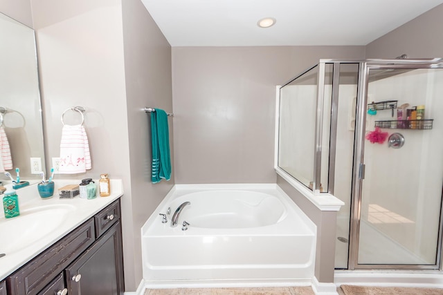 full bathroom with a garden tub, vanity, and a shower stall