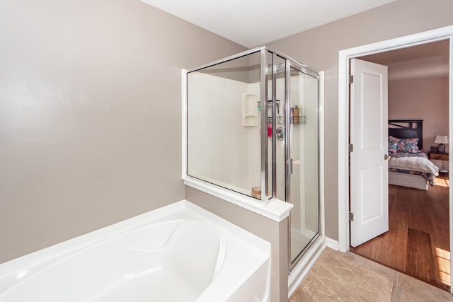 full bathroom with a stall shower, a garden tub, and ensuite bathroom