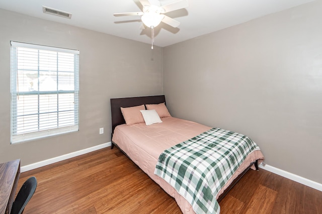 bedroom with visible vents, ceiling fan, baseboards, and wood finished floors