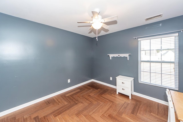 spare room featuring a ceiling fan, visible vents, and baseboards