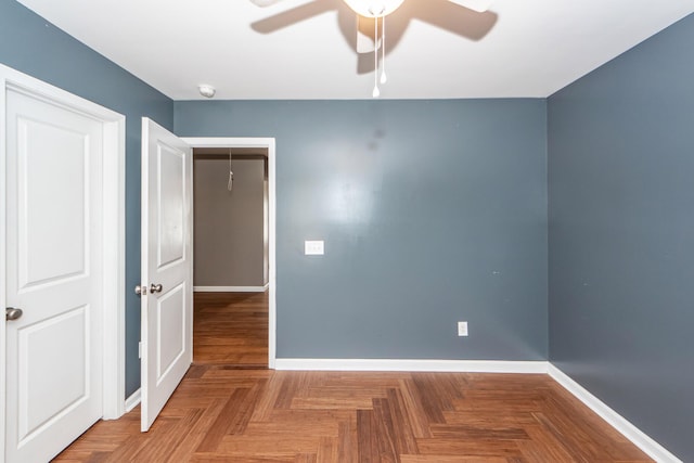 spare room featuring ceiling fan and baseboards