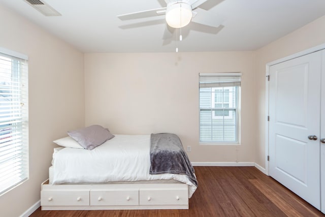 bedroom with visible vents, baseboards, ceiling fan, and dark wood-style flooring