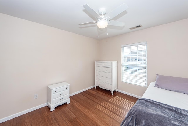 bedroom featuring dark wood finished floors, visible vents, and baseboards