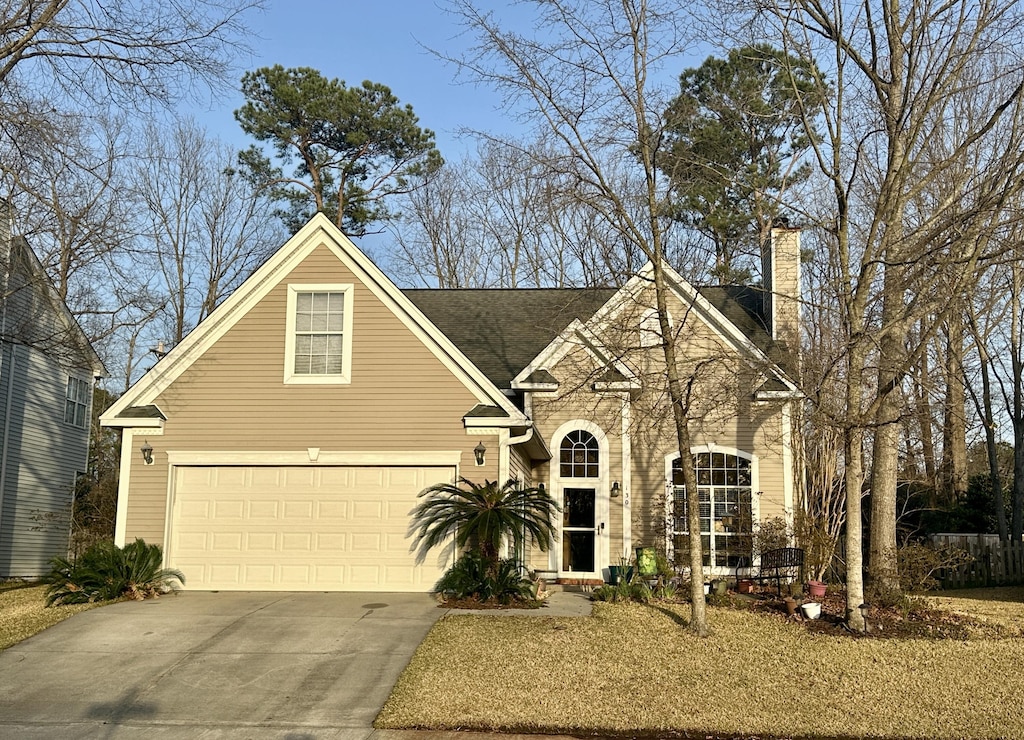 traditional-style home with concrete driveway and a chimney