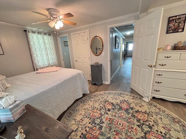 bedroom featuring wood finished floors, ornamental molding, a ceiling fan, and a closet