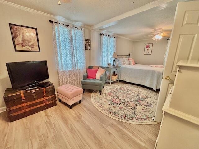 bedroom featuring wood finished floors, crown molding, ceiling fan, and a textured ceiling