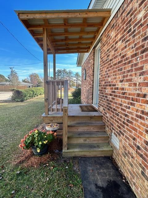 wooden deck featuring a lawn