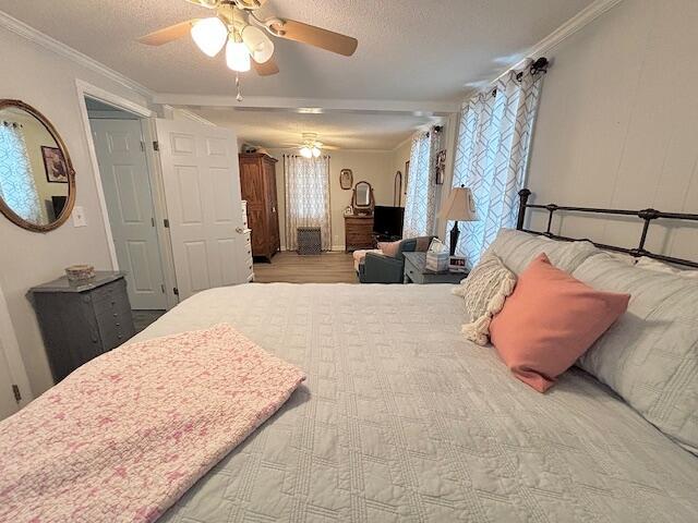 bedroom featuring crown molding, a ceiling fan, and a textured ceiling