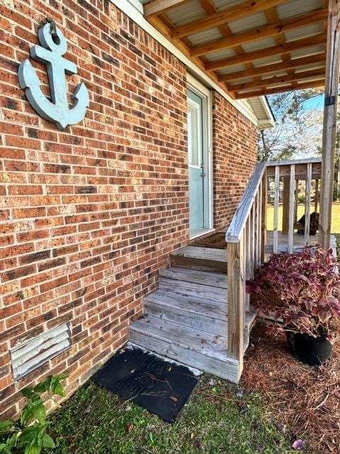 view of exterior entry featuring brick siding