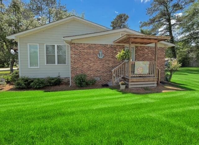 view of front facade featuring brick siding and a front yard