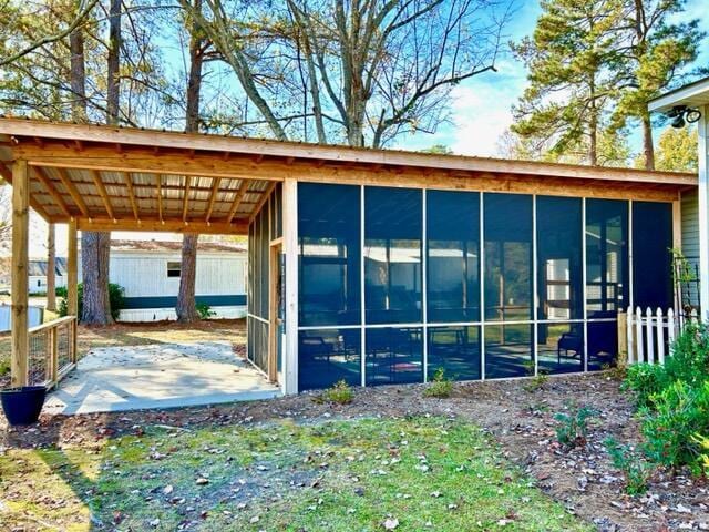 view of side of home with a sunroom and a carport