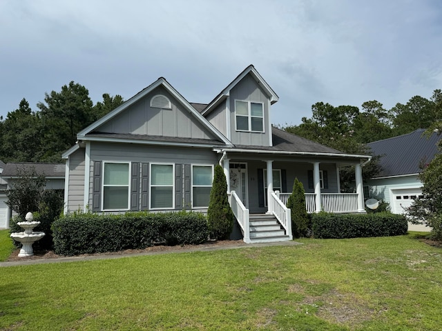 view of front of home featuring a porch, a garage, and a front lawn