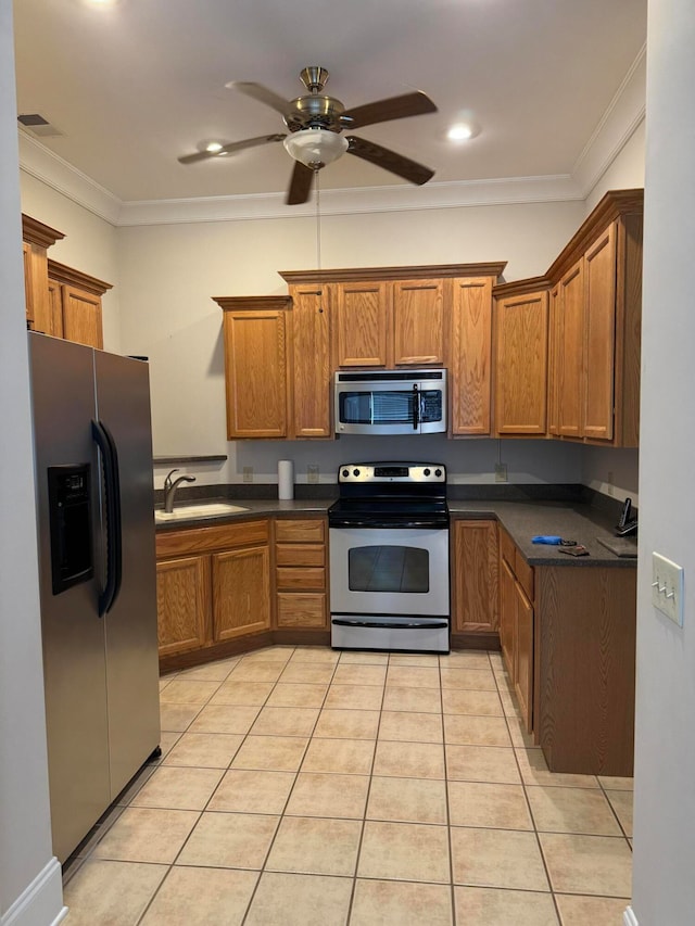 kitchen featuring light tile patterned flooring, crown molding, ceiling fan, stainless steel appliances, and sink