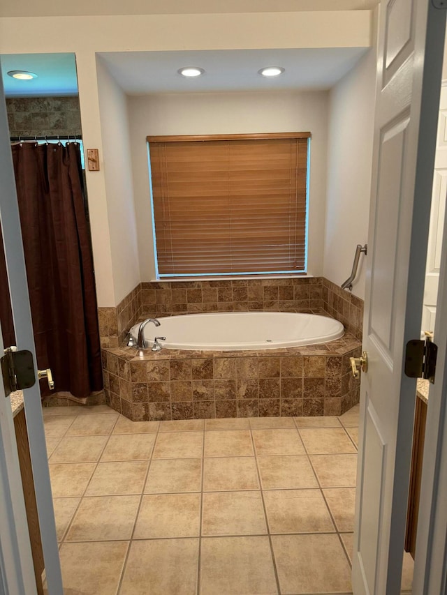 bathroom with a relaxing tiled tub and tile patterned flooring