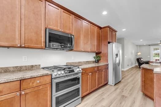 350 Cypress Walk Way, Wando, SC 29492 - kitchen featuring appliances with stainless steel finishes, light wood-style flooring, recessed lighting, brown cabinets, and a ceiling fan