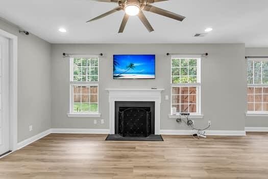 350 Cypress Walk Way, Wando, SC 29492 - unfurnished living room featuring wood finished floors, plenty of natural light, a ceiling fan, a fireplace, and recessed lighting