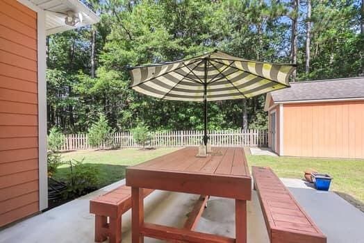 350 Cypress Walk Way, Wando, SC 29492 - fenced backyard featuring outdoor dining area, an outbuilding, a patio area, and view of scattered trees