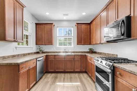 350 Cypress Walk Way, Wando, SC 29492 - kitchen featuring appliances with stainless steel finishes, light wood finished floors, brown cabinets, and recessed lighting