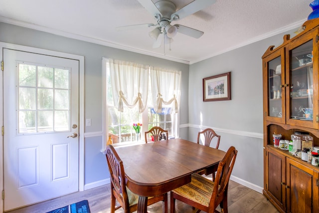 dining space featuring a textured ceiling, crown molding, ceiling fan, and hardwood / wood-style flooring