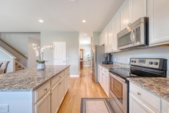 109 Cypress Plantation Rd, Moncks Corner, SC 29461 - kitchen with stainless steel appliances, a center island, white cabinetry, light stone counters, and recessed lighting