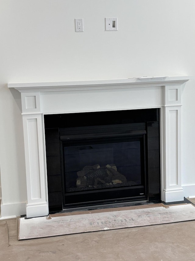 room details featuring a glass covered fireplace and baseboards