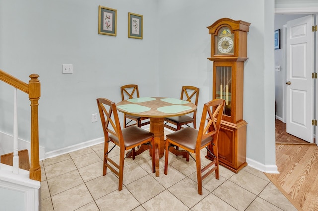 dining room featuring stairs, baseboards, and light tile patterned flooring