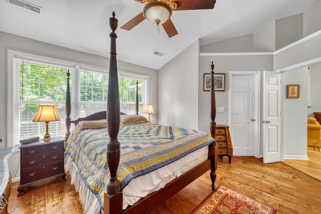 bedroom with ceiling fan, light hardwood / wood-style floors, and vaulted ceiling