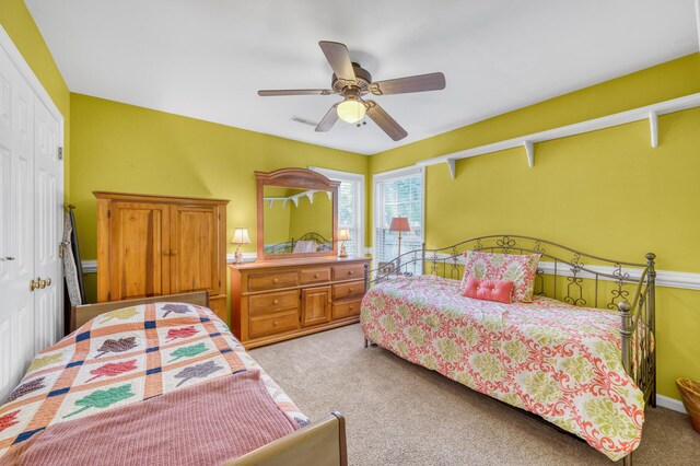 bedroom featuring a closet, ceiling fan, and light colored carpet