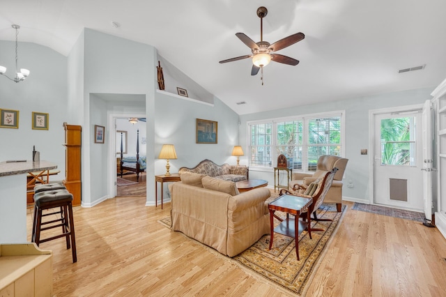 living room featuring light wood-style floors, visible vents, baseboards, and ceiling fan with notable chandelier