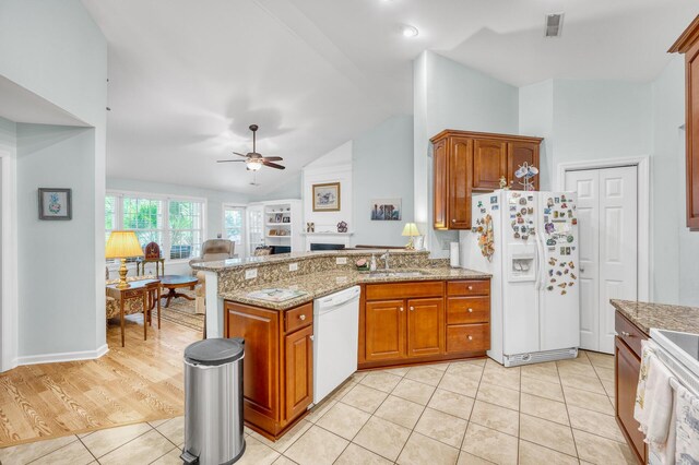 kitchen with white appliances, sink, light stone countertops, ceiling fan, and light hardwood / wood-style floors