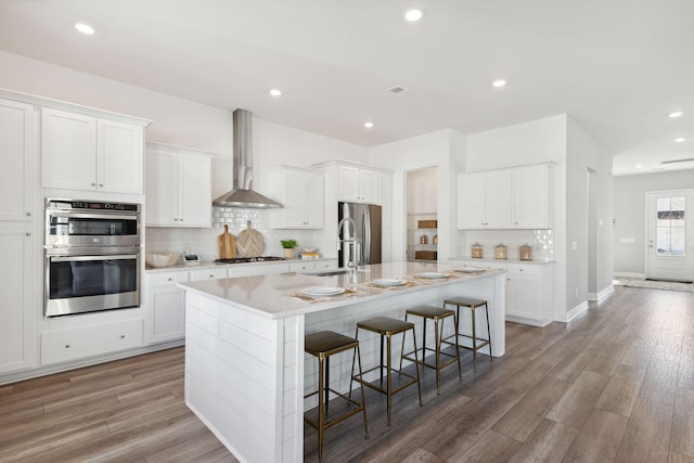782 Clay Field Trl, Summerville, SC 29485 - kitchen featuring stainless steel appliances, tasteful backsplash, a kitchen breakfast bar, a kitchen island with sink, and wall chimney exhaust hood