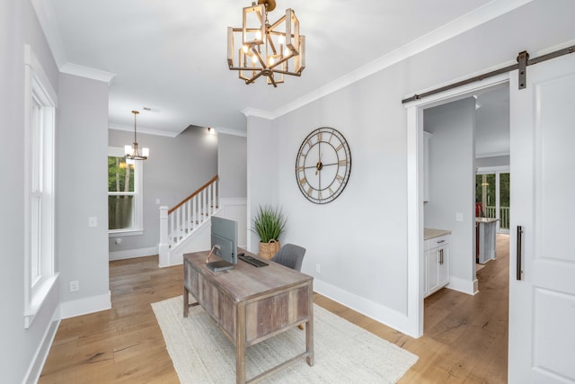 home office with crown molding, a barn door, a healthy amount of sunlight, and light hardwood / wood-style flooring