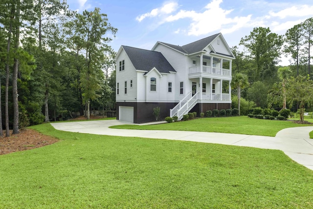 exterior space featuring a balcony, covered porch, a garage, and a yard