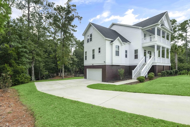 view of side of property with a garage, a lawn, and a balcony