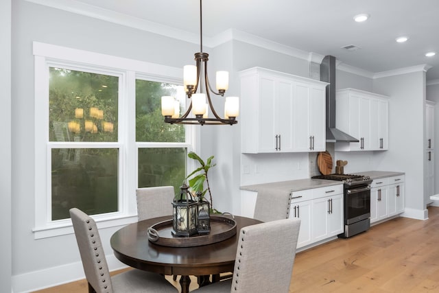 dining area featuring light wood-type flooring, a notable chandelier, and crown molding