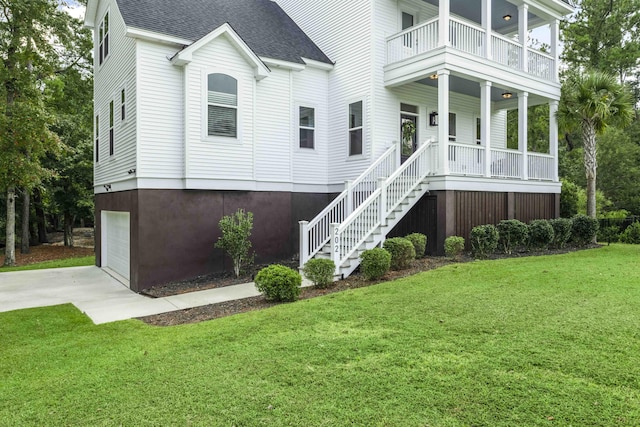 exterior space with a garage, a front lawn, and a balcony