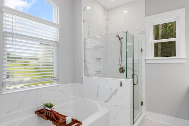 bathroom with a wealth of natural light and separate shower and tub