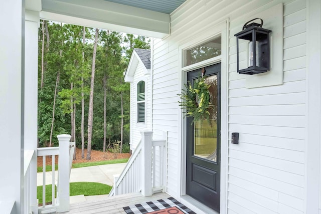 view of exterior entry featuring covered porch