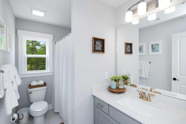 bathroom with toilet, vanity, and tile patterned floors