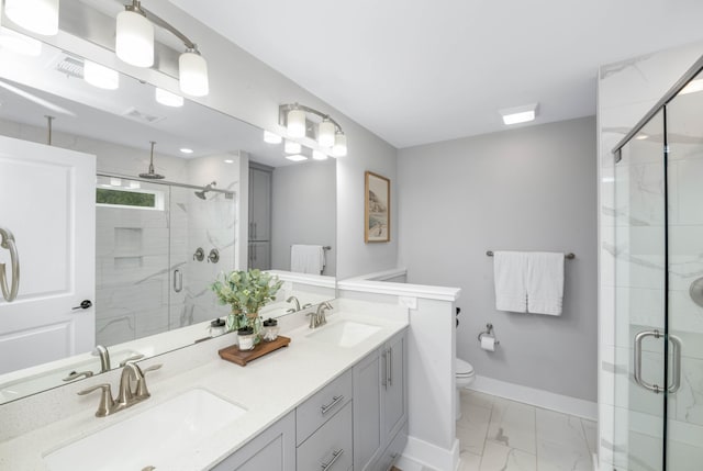 bathroom featuring a shower with door, vanity, and toilet