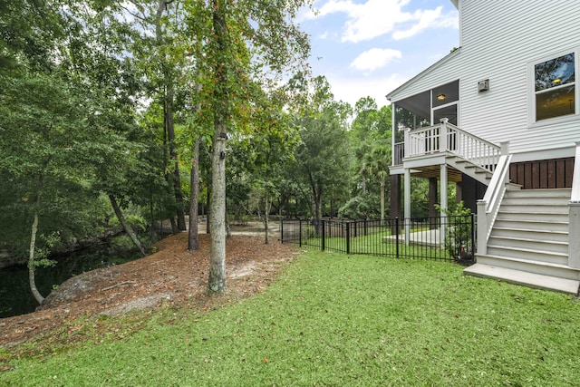 view of yard featuring a sunroom and a wooden deck