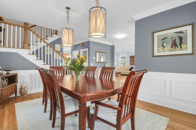 dining space featuring hardwood / wood-style flooring, crown molding, and a chandelier