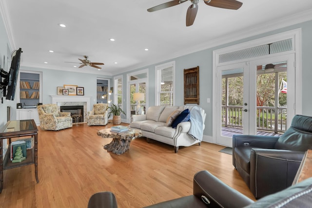 living room with french doors, light hardwood / wood-style floors, ornamental molding, and a wealth of natural light