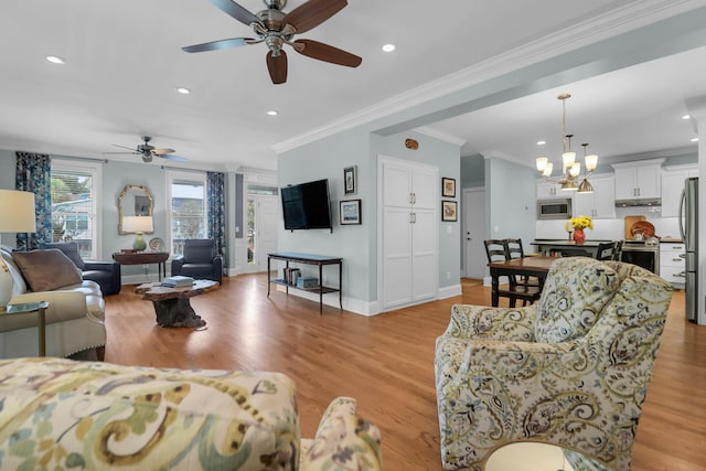 living room with ornamental molding, ceiling fan with notable chandelier, and light hardwood / wood-style flooring